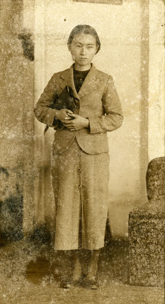 A sepia studio portrait of a young woman covered in spots and mold