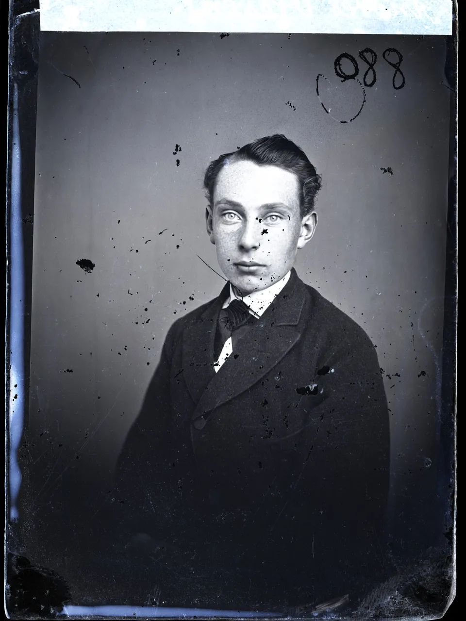 A portrait of a man in a suit from a glass plate covered in white spots