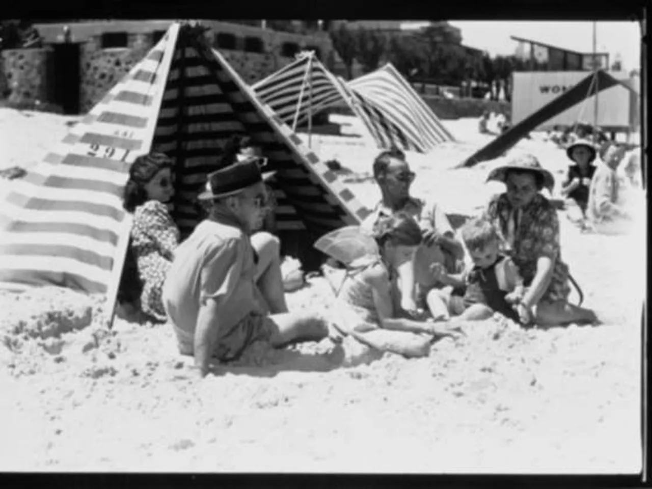 Una piccola foto compressa in bianco e nero di una famiglia sotto una tenda a righe